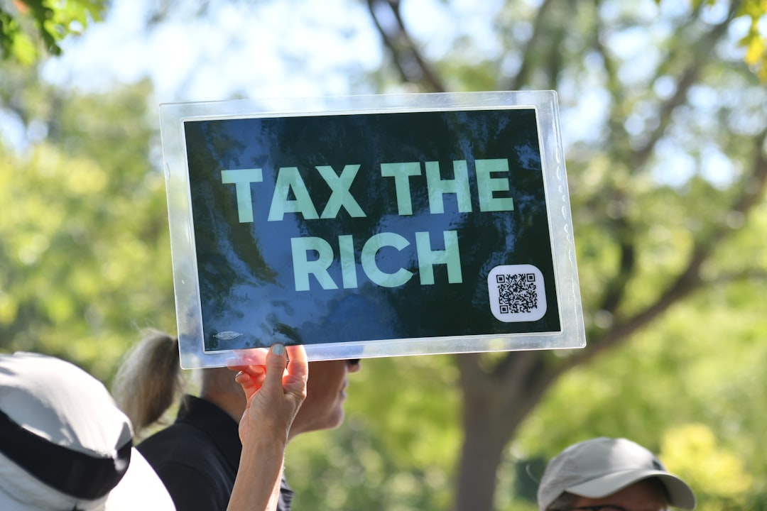 person-holds-sign-that-says-tax-the-rich-xfvdowayreq